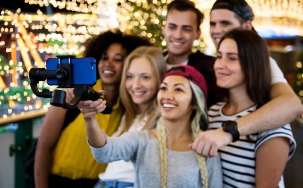 Group of young adults filming themselves with an iPhone