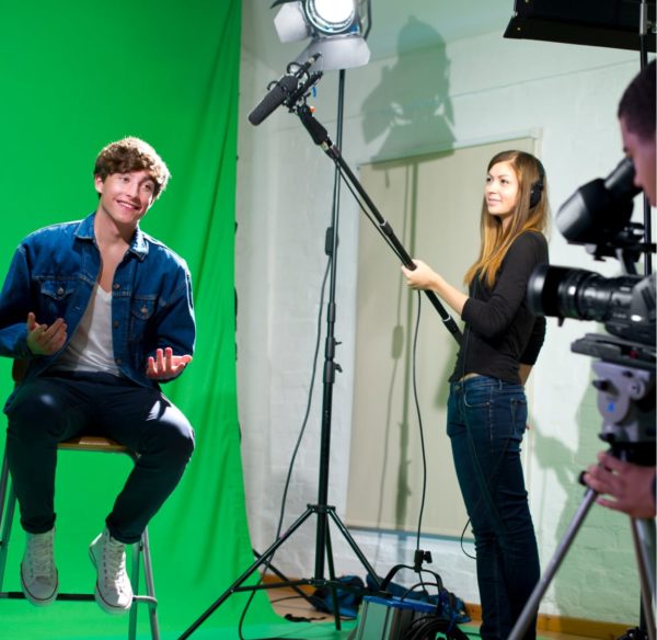Young adults filming on a green screen set